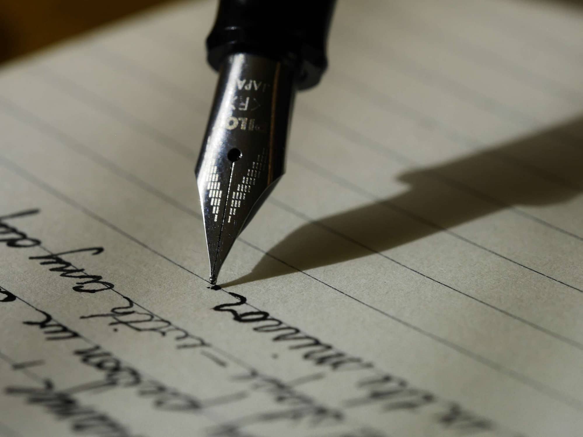 Ein Füller, der auf einem linierten Papier schreibt.