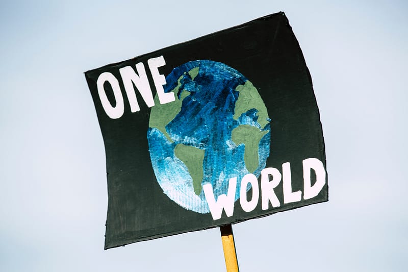 Protest-Schild mit der Aufschrift "one World" und Darstellung einer Weltkugel darauf